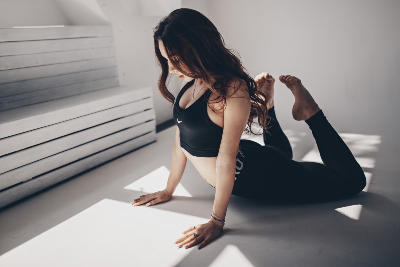 Brunette woman in fitness attire doing yoga pose