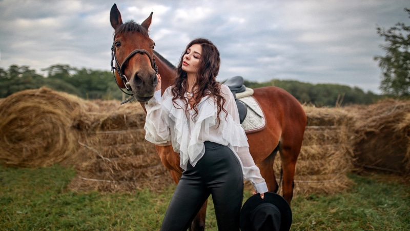 Woman with horse and hay bales