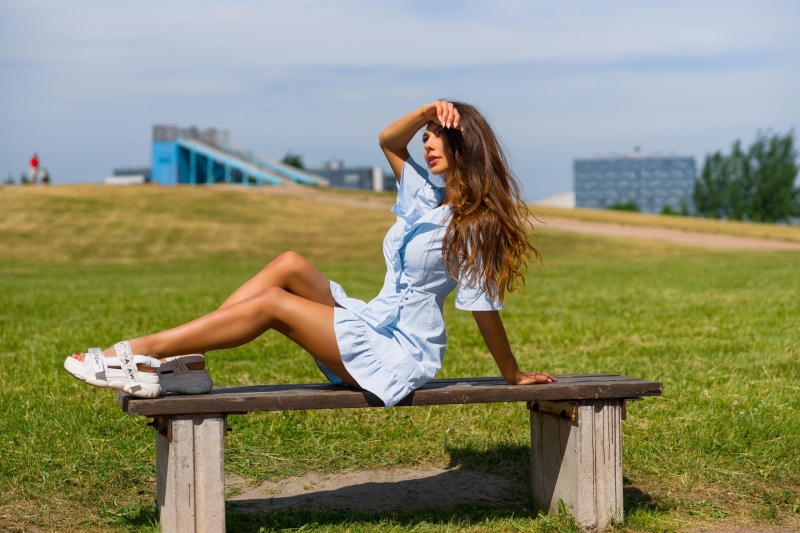 Woman in blue dress sitting on a park bench