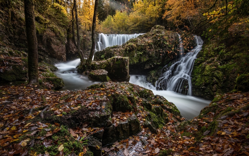 Autumn Waterfall with Foliage and Stones