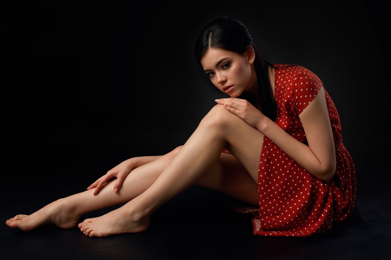 Brunette girl in red polka dot dress sitting