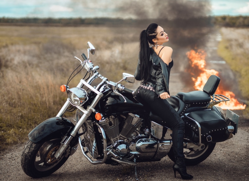 Woman in leather jacket on a motorcycle with fire