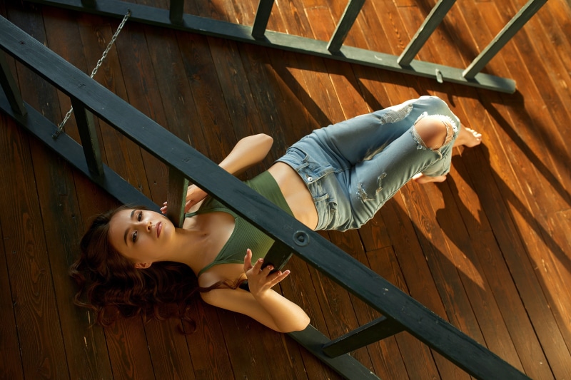 Yulia Metlyakova lying on wooden floor near stairs