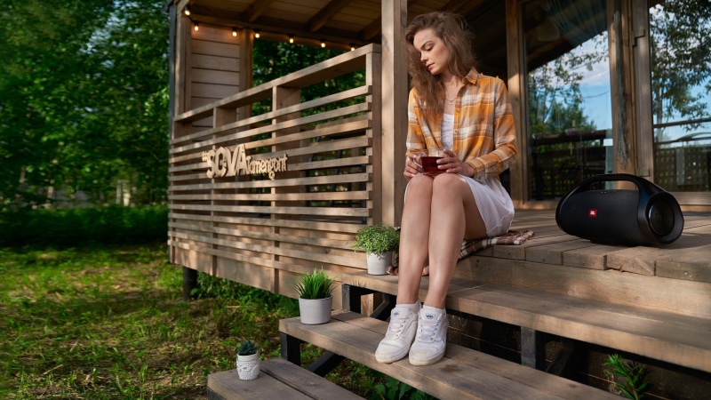 Maria Kudryavtseva sitting on porch with tea and JBL speaker
