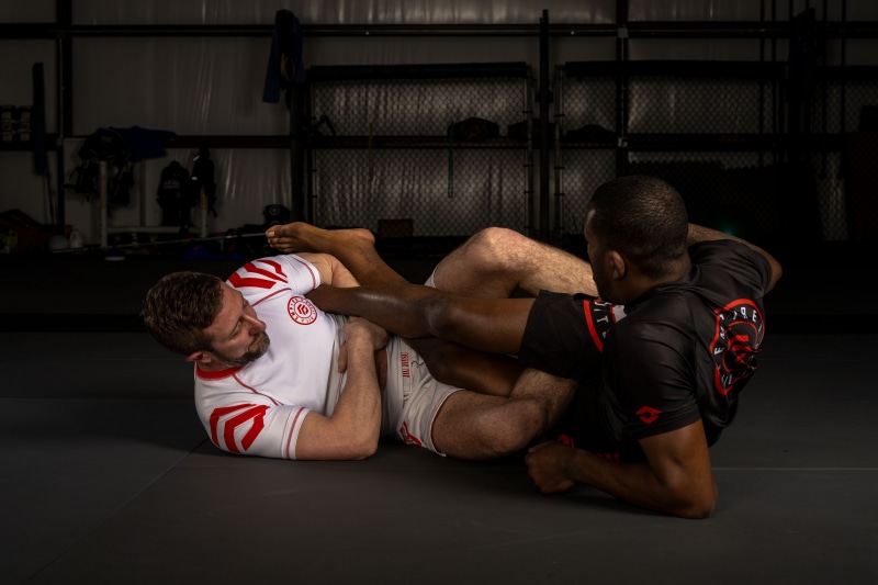 Two men practicing jiu-jitsu on a mat