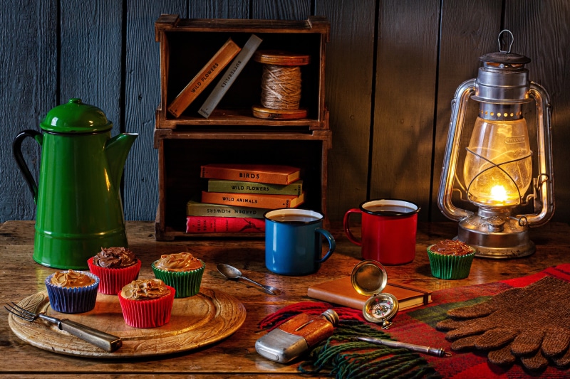 Still-life with Kerosene lamp, Kettle, Cupcakes, Books, and Gloves