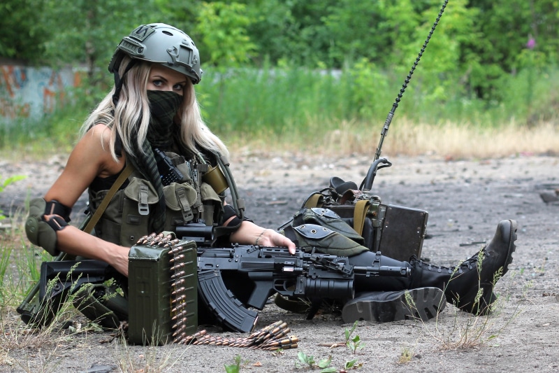Blonde woman with AK assault rifle and ammo