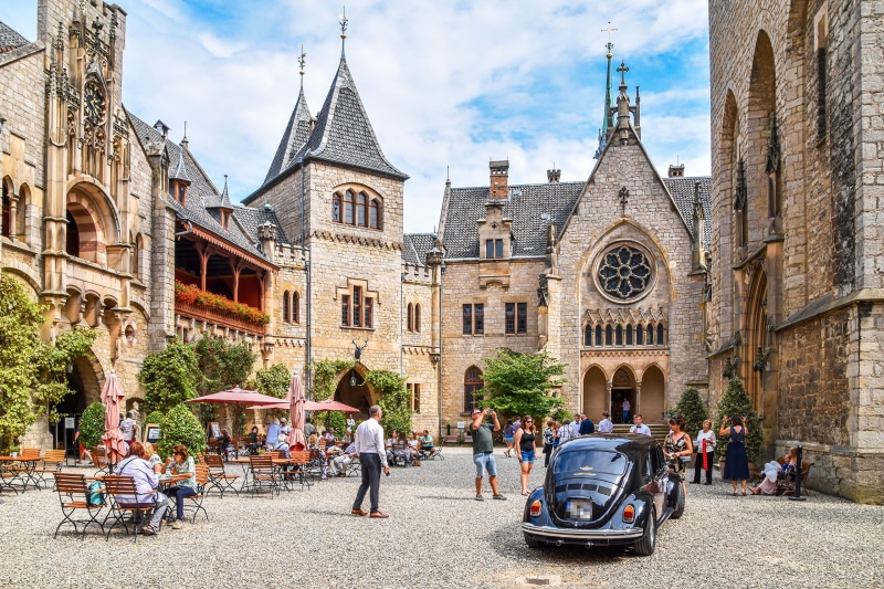 Marienburg Castle courtyard with people and a vintage car