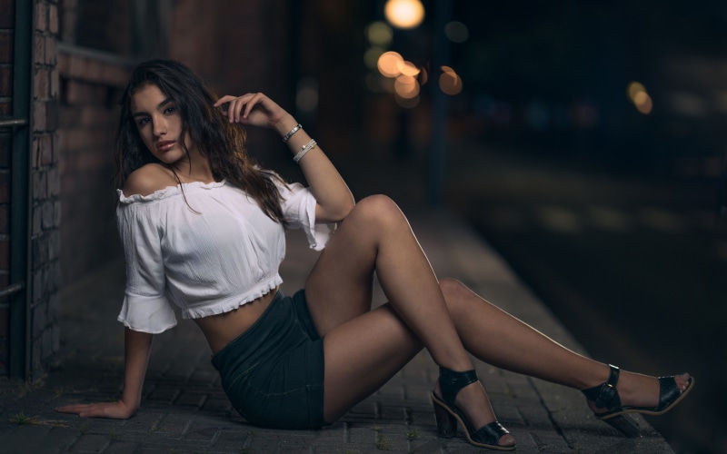 Brunette girl sitting at night with bokeh