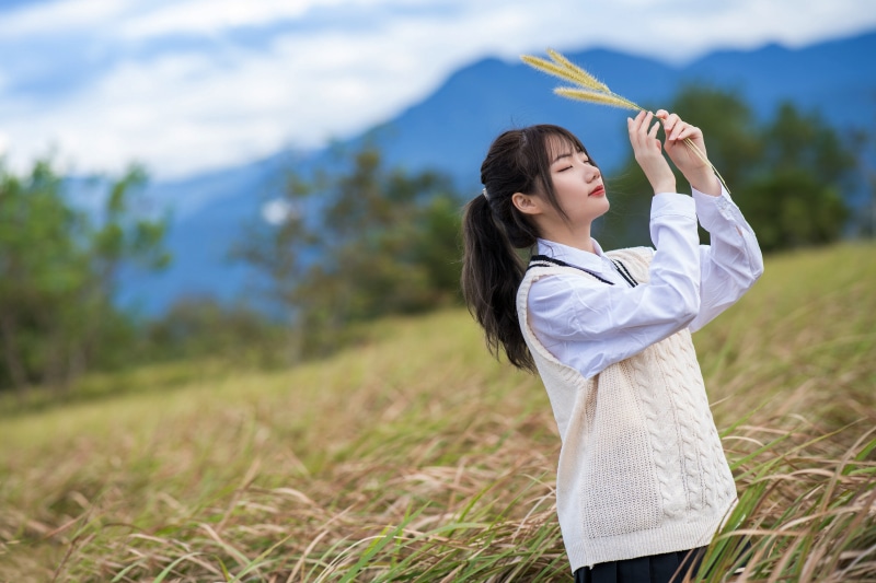 Asian girl in a field holding wheat
