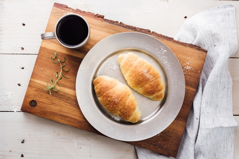 Coffee and croissants on a cutting board
