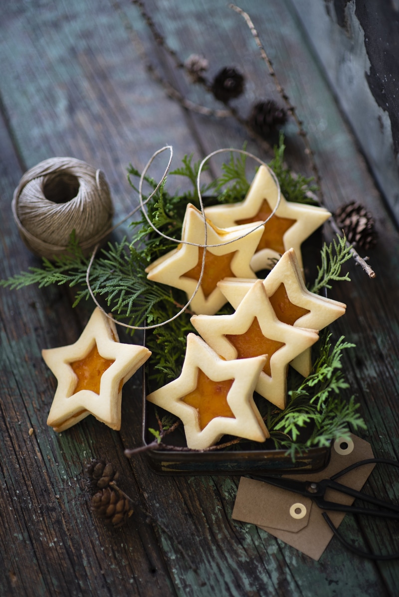 Star-shaped cookies with jam on a wooden table