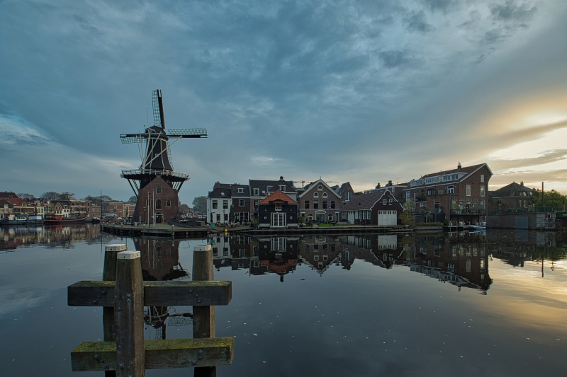 Windmill and houses by the river in Haarlem, Netherlands