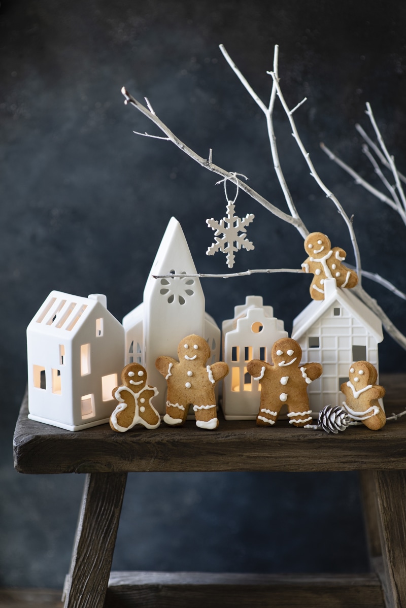 Gingerbread men and ceramic houses on a wooden bench