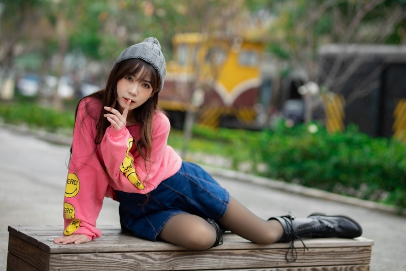 Asian girl in pink sweatshirt and denim skirt