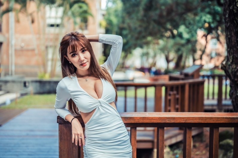 Asian woman in white dress posing outdoors