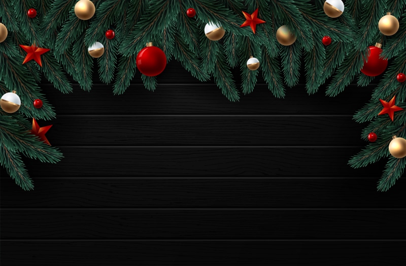 Christmas fir branches with ornaments and stars on black wood