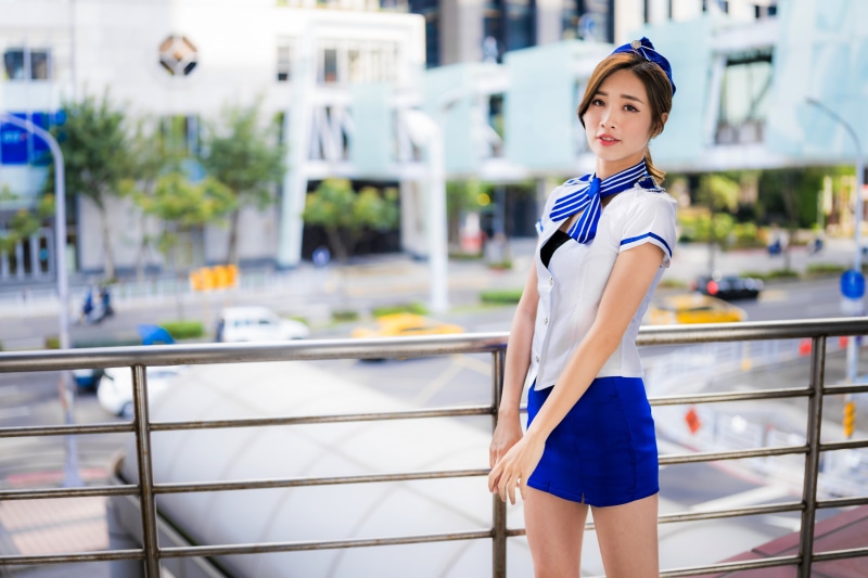 Asian stewardess in uniform with blue scarf and hat
