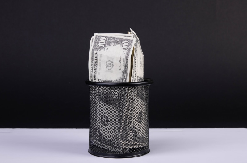 US Dollar Bills in a Mesh Wastebasket