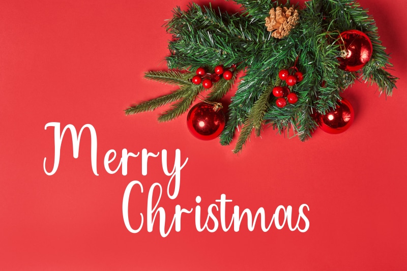 Merry Christmas text with pine branches and ornaments
