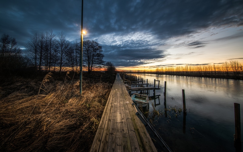 Wooden pier and river at sunrise in Sweden