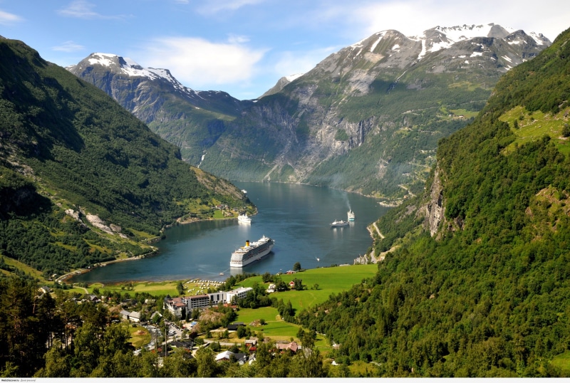 Cruise ships in a Norwegian fjord with mountains and forests
