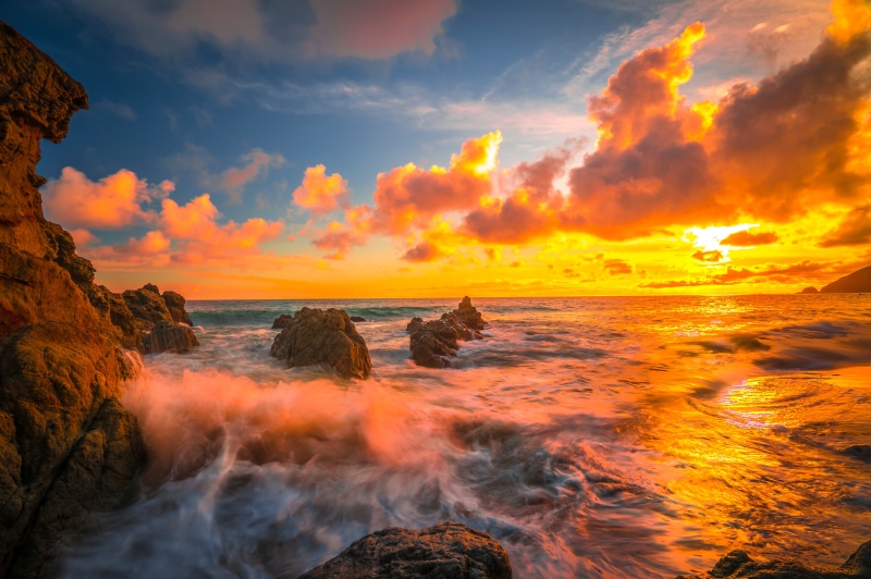 Sunset over the ocean with rocky coast in California