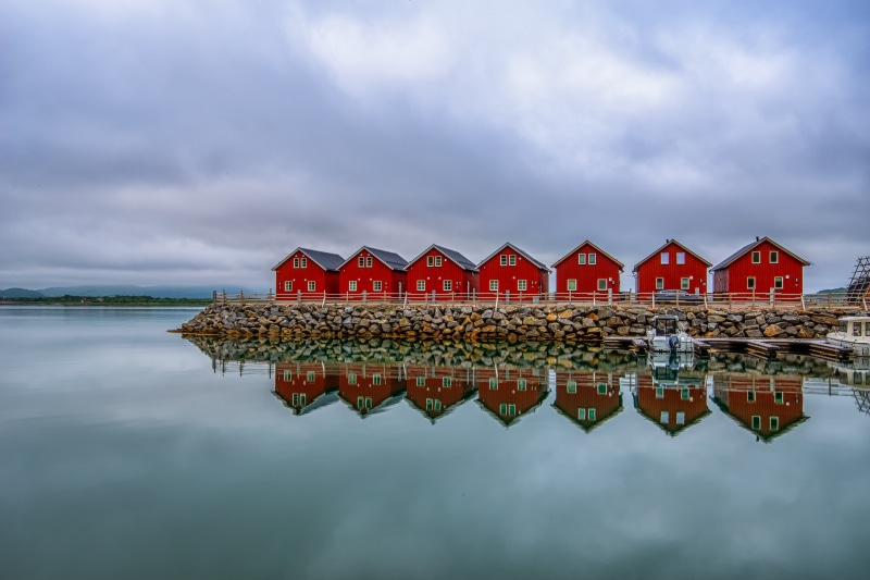 Red Rorbuer houses in Lofoten, Norway with reflection