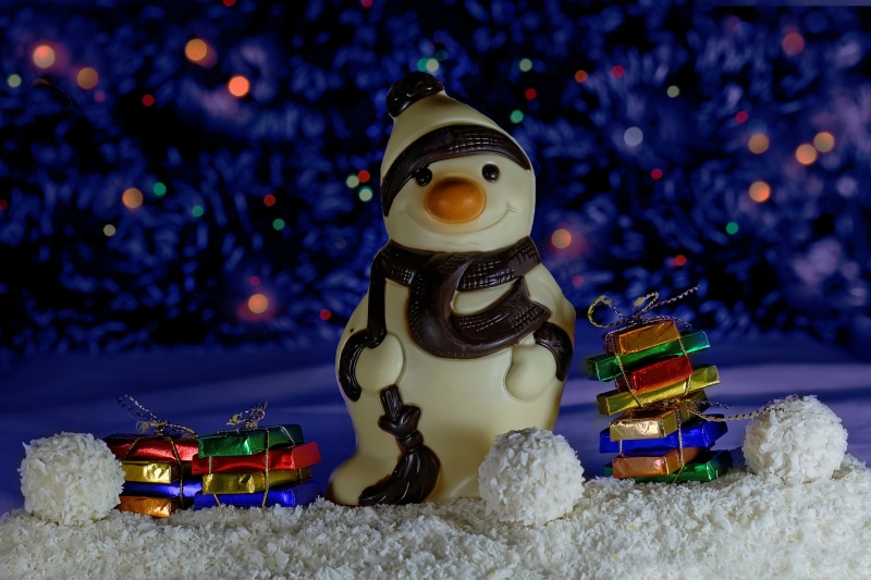 Chocolate Snowman with Christmas Gifts and Bokeh Lights