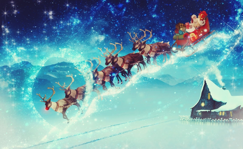 Santa Claus and reindeer sleigh flying over snowy landscape