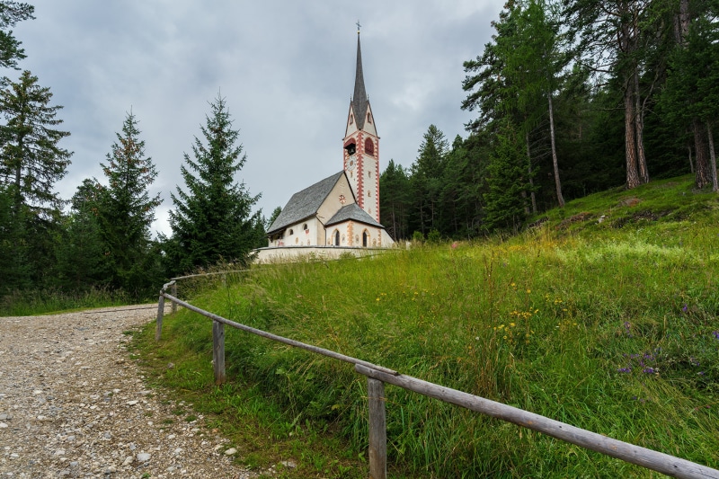 Church in a forest clearing with a dirt path