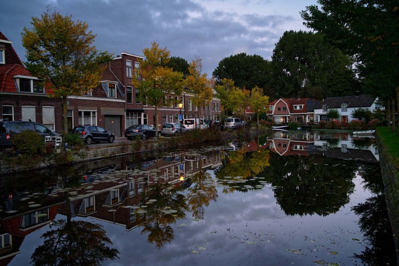 Houses along a canal in Weesp, Netherlands at dusk