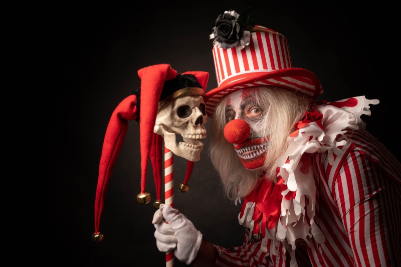 Scary Clown Holding a Skull on a Stick