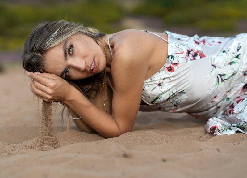 Lily Gilbert in a floral dress on sand