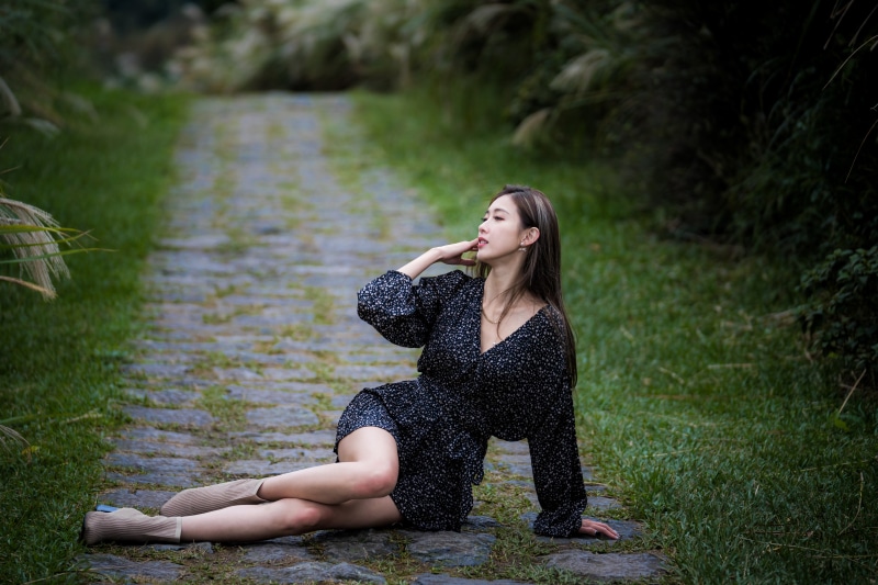 Asian woman in dress posing on stone path
