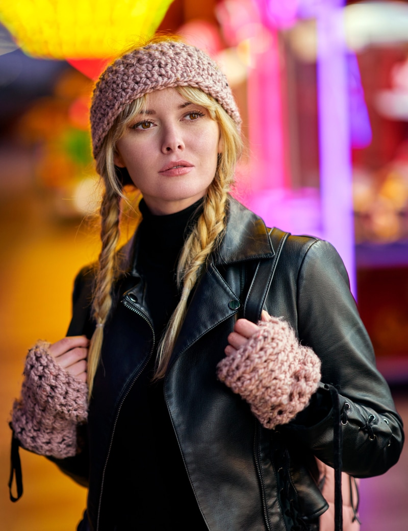 Blonde woman with braided hair wearing a winter hat and jacket