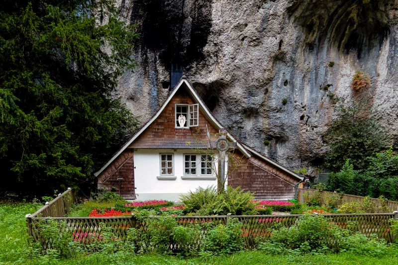 House built into a crag in Switzerland with a garden