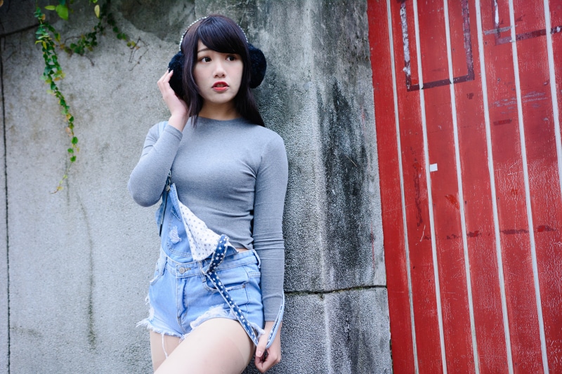 Asian girl with headphones and denim overalls