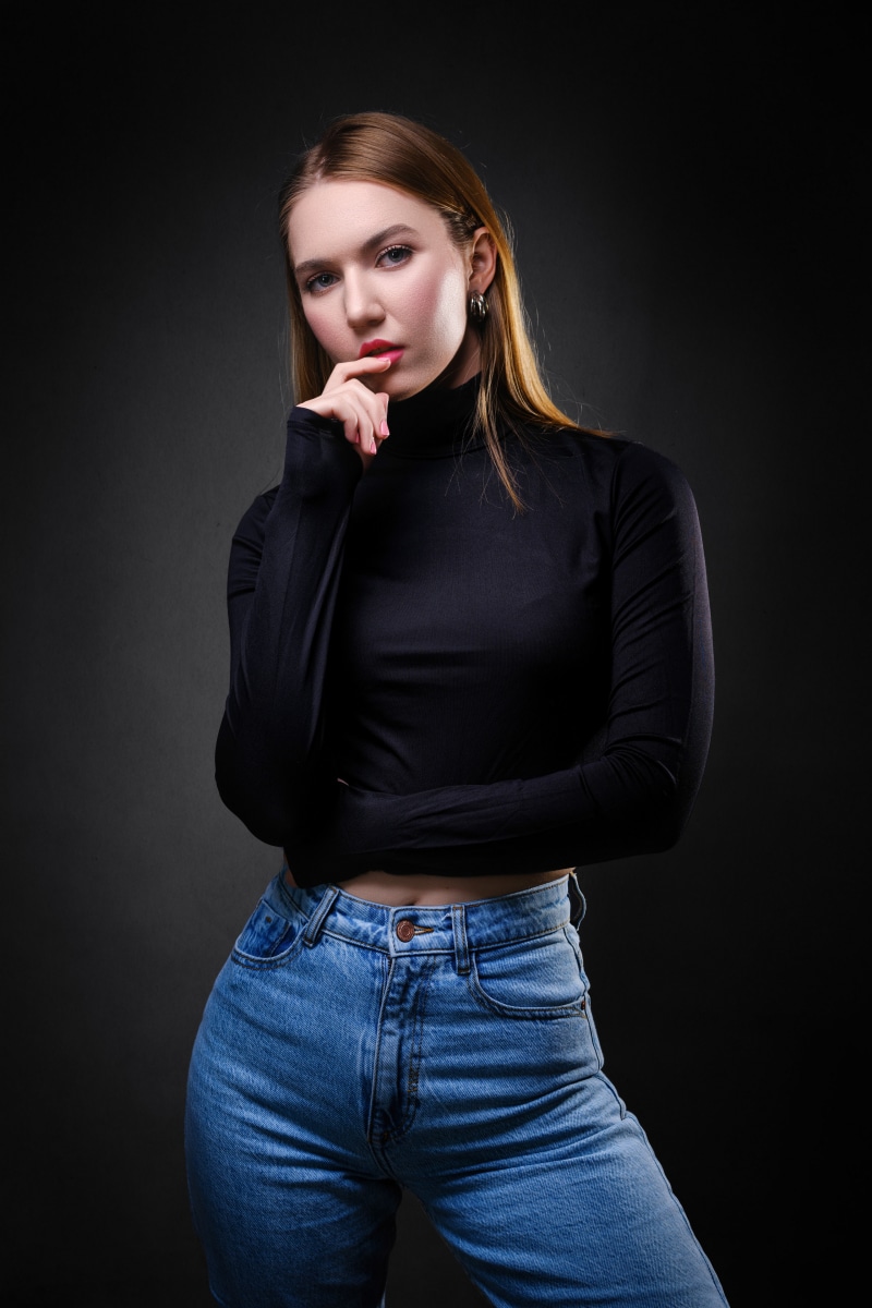 Woman in black turtleneck and jeans posing