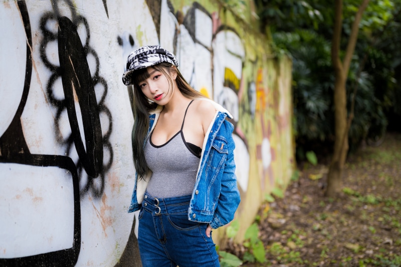 Asian woman in baseball cap and denim jacket