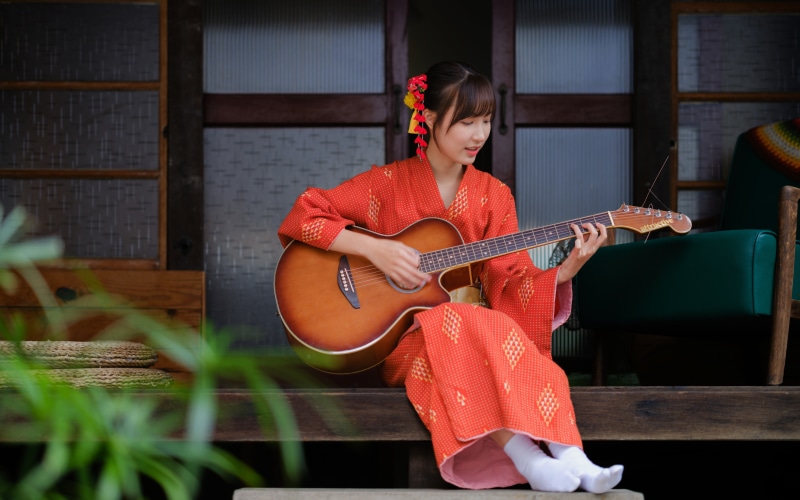 Asian woman in Kimono playing guitar