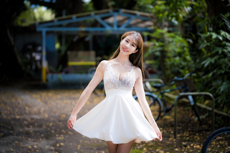 Asian woman in white dress smiling