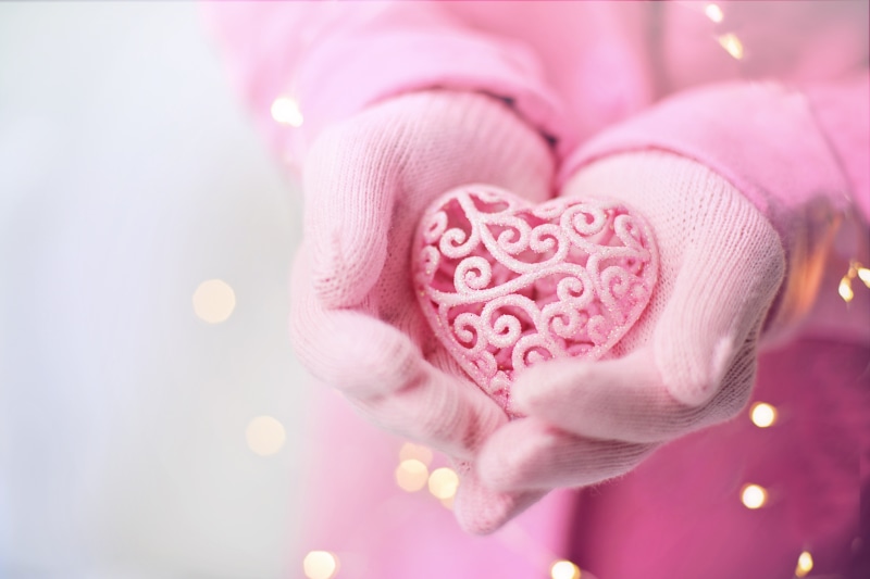 Pink Heart Ornament Held in Pink Gloves with Bokeh Lights