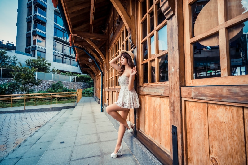 Asian woman in dress and hat posing