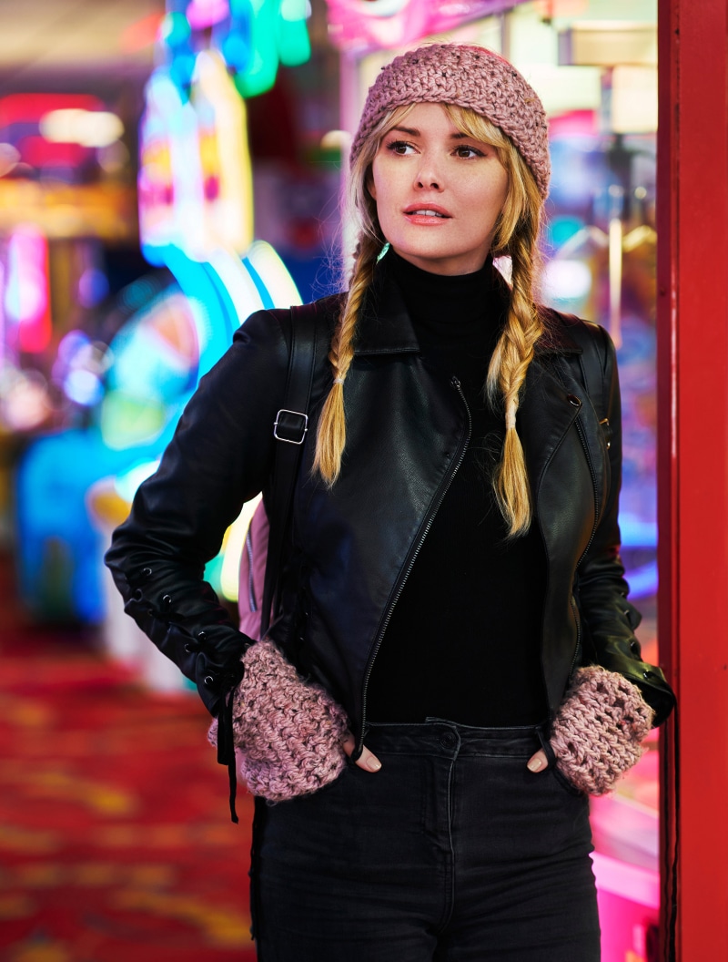 Blonde girl with braided hair wearing a beanie and leather jacket
