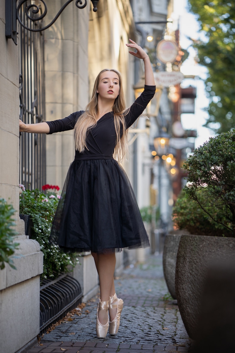 Ballet dancer in black tutu posing outdoors