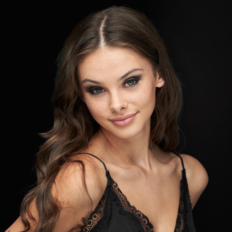 Meika Woollard smiling against black background
