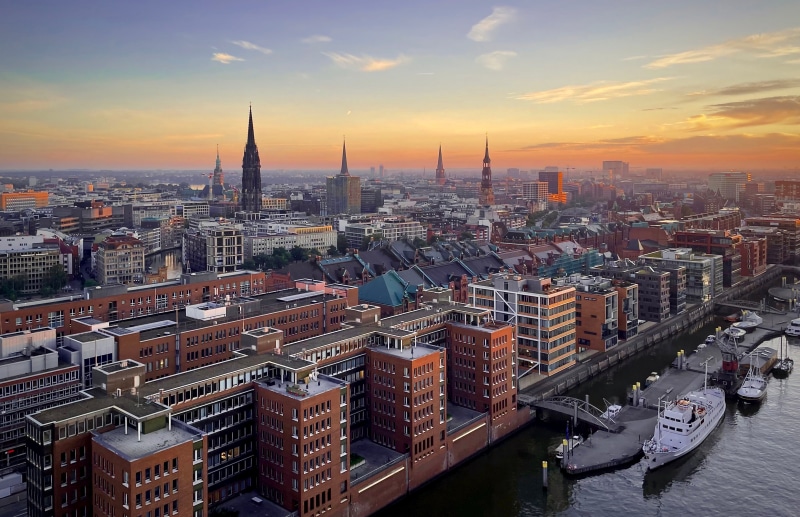 Hamburg skyline with churches and riverboats at sunset