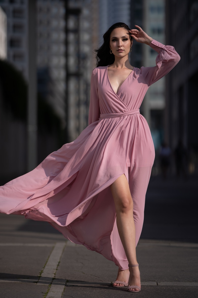 Woman in pink dress posing outdoors