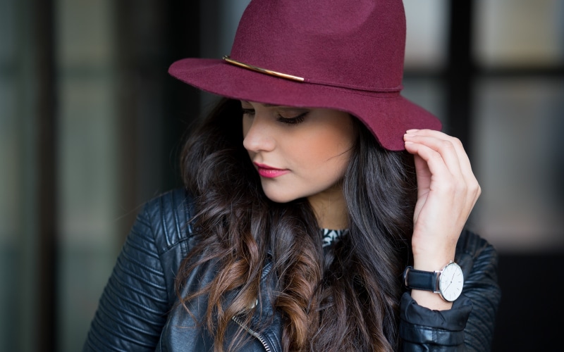 Brunette girl wearing a burgundy hat and leather jacket